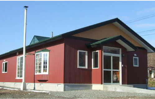 緑色の屋根と茶色を基調とした外壁のバリアフリーなくまさん荘の外観写真