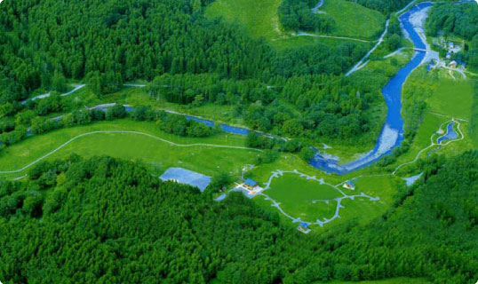 森林が広がる敷地内にキャンプ場やパークゴルフ場の施設があるニセウ・エコランドを上空から撮影した写真