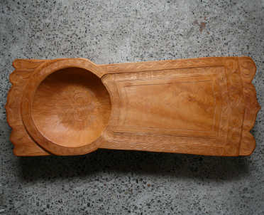 木製で左に円形にくり抜いたような椀と右がまな板のように平らになったかたちの「メノコイタ」の写真