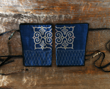 左右対称に置かれた2枚の紺地の布に下が籠目柄で上部に模様が刺繍されている貝澤 守さんが作った「ホシ」の写真